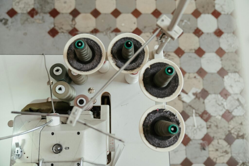 pexels-photo-4614126-4614126 Aerial view showcasing the setup of a sewing machine with thread spools, perfect for textile industry content.